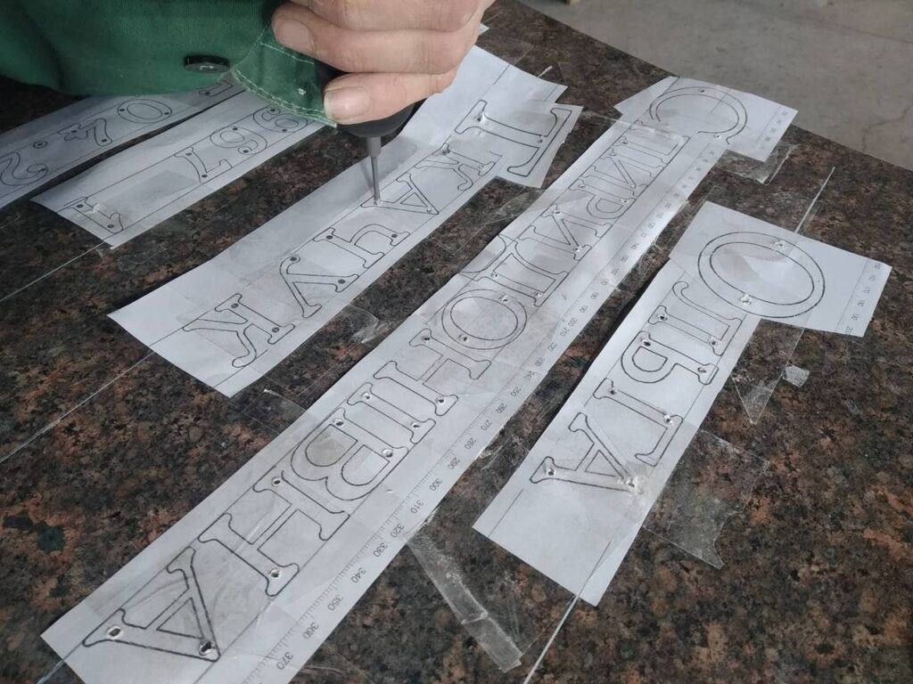 Підготовка напису на камені за паперовими шаблонами літер.