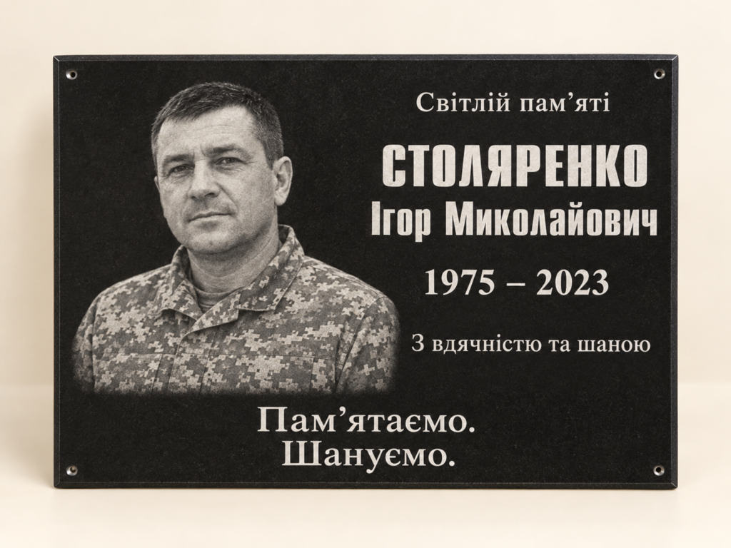 Каталожна візуалізація чорної меморіальної дошки з вигаданим портретом військового та зразком українського напису.